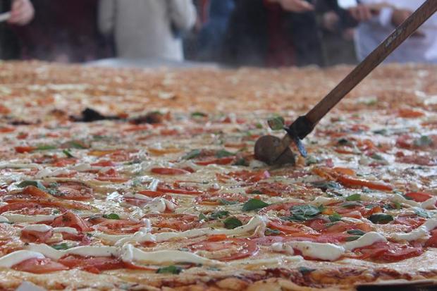 Com 3,11 m de diâmetro e 156,11kg, a pizza gigante foi servida para crianças da rede municipal de ensino / Foto: RankBrasil