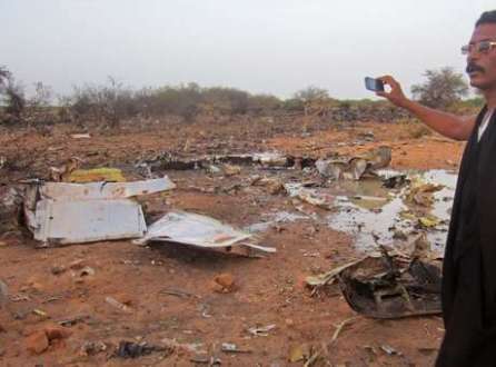 Um homem tira foto dos detroços do avião que caiu no Mali com 118 pessoas a bordo