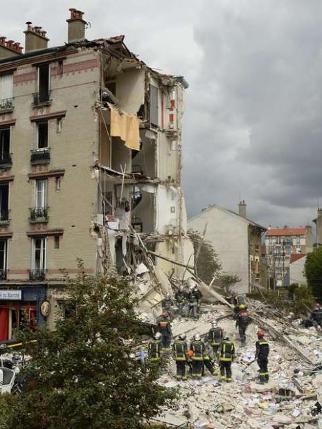 Bombeiros trabalham em escombros após explosão de prédio em Paris