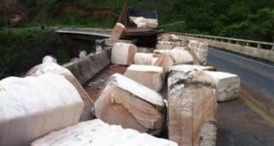 Parte da carga ficou espalhada sobre a ponte na BR-365 (Foto: Taislaine Antunes / G1)