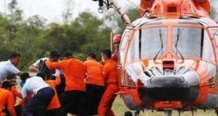 Equipes de resgate e busca da Indonésia descarregam corpo de duas vítimas do acidente