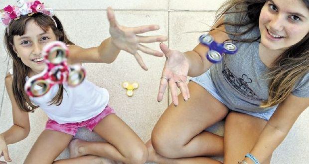 Brincadeira. As irmãs Marina, 9, e Giulia, 13, se divertem com o spinner e são acompanhadas de perto pela mãe