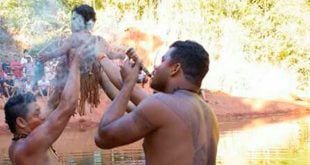 Criança indígena batizada em rio