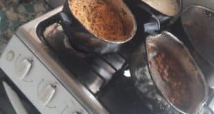 Em um fogão, havia  uma panela com restos de comida, macarrão e arroz endurecidos.