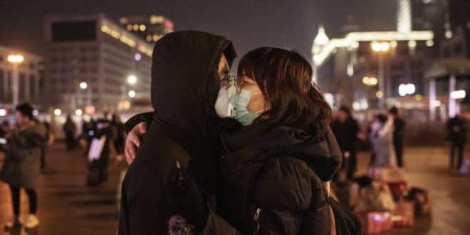 Por coronavírus, casal chinês se beija usando máscaras de proteção antes de pegar o trem em estação de Pequim, antes do Festival de Primavera (22/01/2020) Kevin Frayer/Getty Images