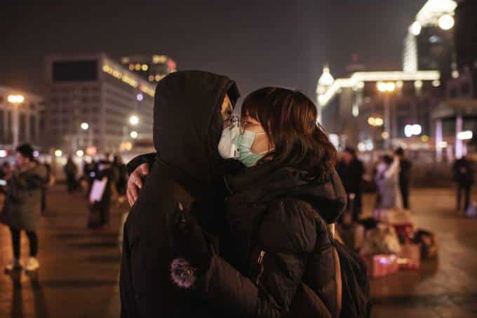 Por coronavírus, casal chinês se beija usando máscaras de proteção antes de pegar o trem em estação de Pequim, antes do Festival de Primavera (22/01/2020) Kevin Frayer/Getty Images