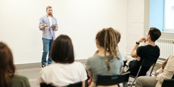 Homem segurando tablet palestra para pessoas