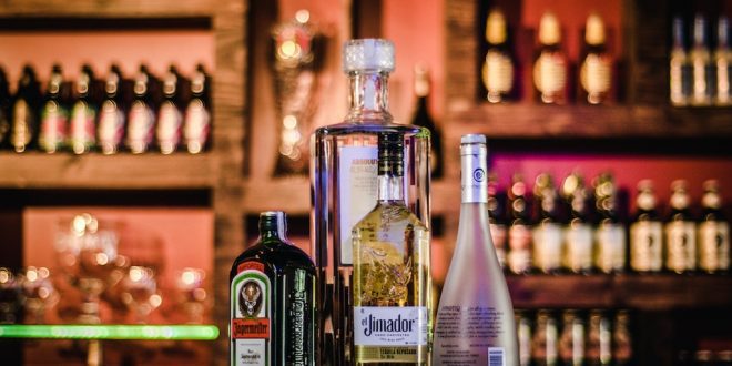 Quatro garrafas de licor em balcão de bar